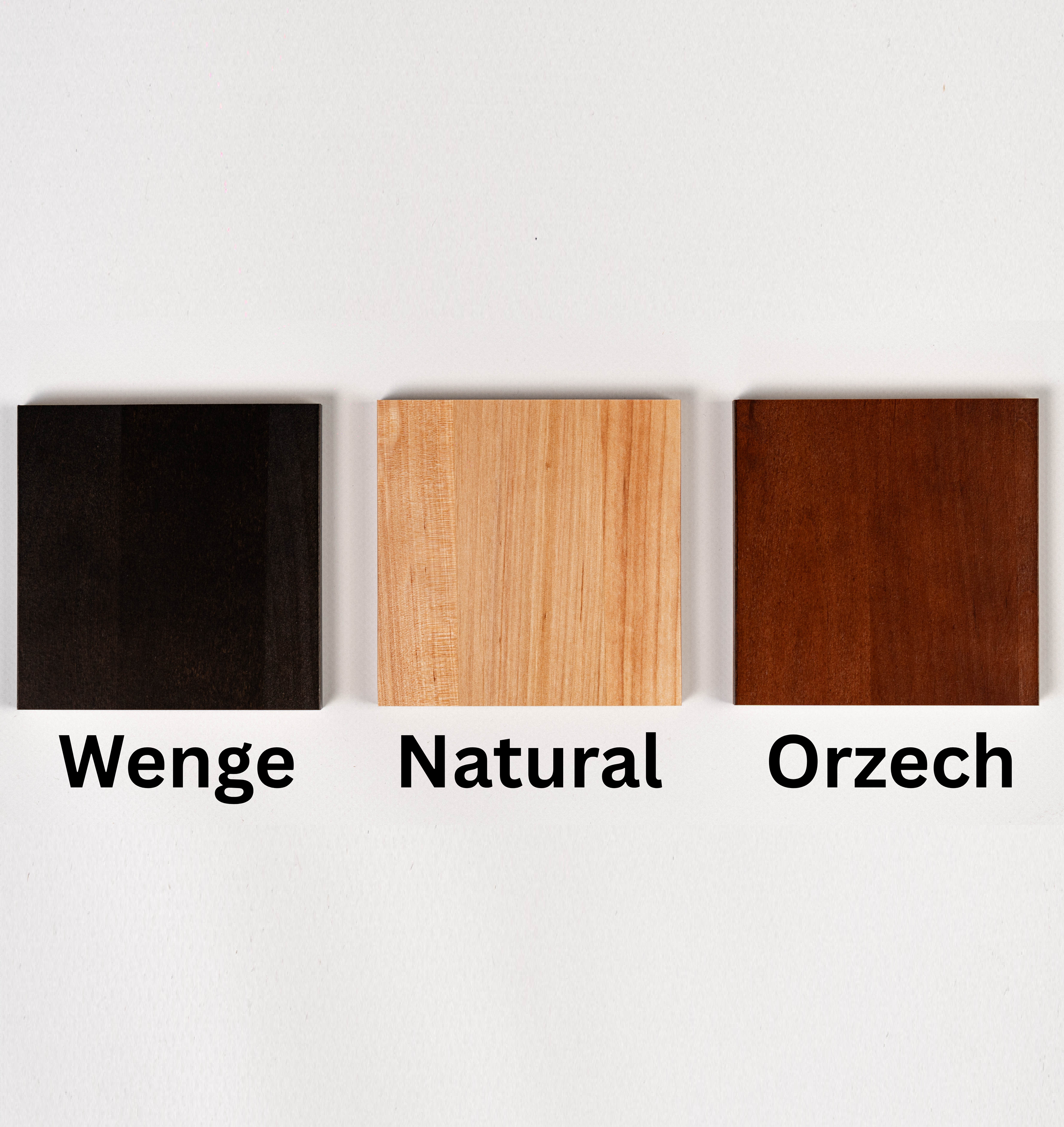 Próbki wybarwienia drewna na białym tle: Wenge (ciemne), Natural (jasne) i Orzech (ciepły brąz). Opcje kolorystyczne mebli drewnianych.